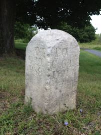Here's the first circa 1818 Bedford-Stoystown Turnpike marker that we found along the Lincoln Highway. Notice the typo on the left side of the stone: it says "OT" instead of "TO." (Photo by Jennifer Sopko)